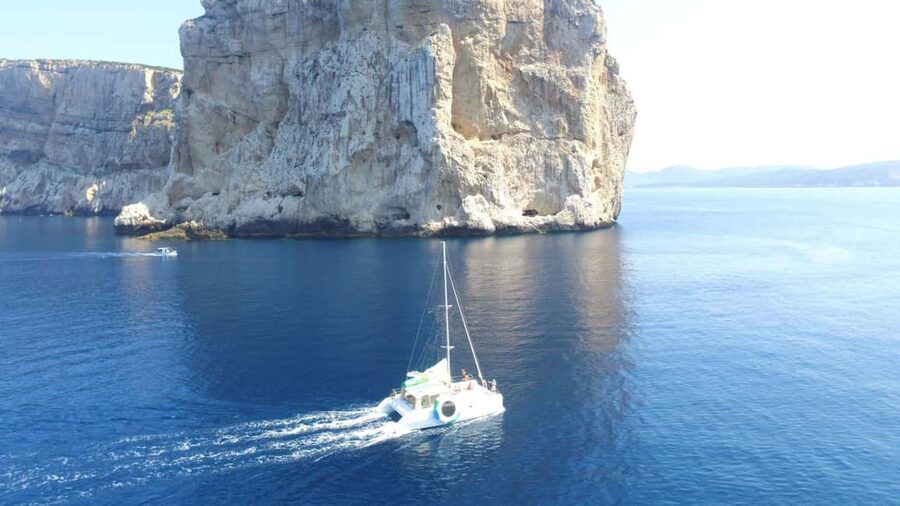 Porto Conte: Half-day catamaran tour with aperitif - Sailing toward Capo Caccia